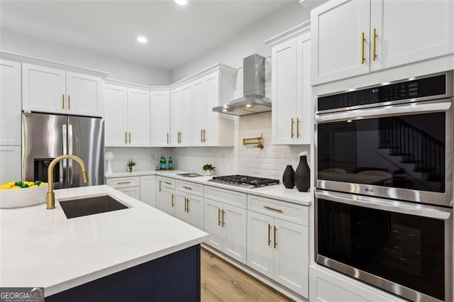 2438 2nd St, Atlanta, GA 30318 - kitchen with appliances with stainless steel finishes, wall chimney exhaust hood, light countertops, white cabinetry, and recessed lighting