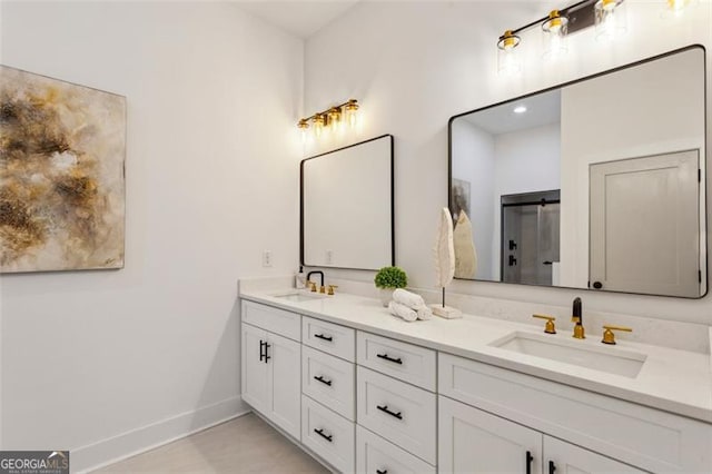 bathroom with baseboards, a sink, and double vanity