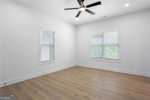 empty room with baseboards, wood finished floors, and visible vents
