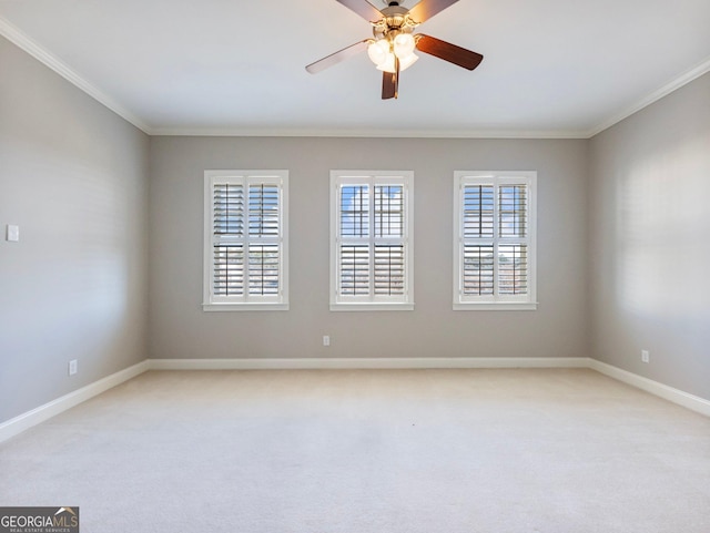 spare room featuring crown molding, ceiling fan, light carpet, and baseboards