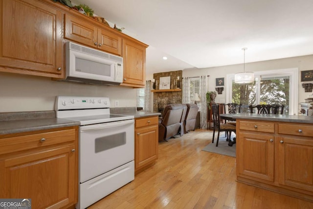 kitchen with white appliances, recessed lighting, brown cabinetry, and light wood finished floors
