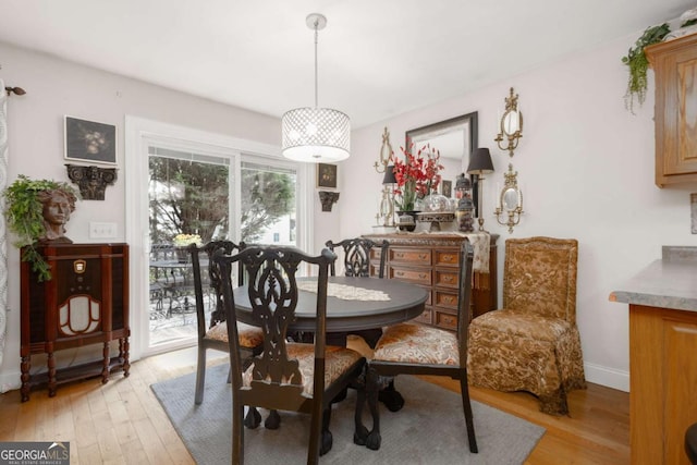 dining space with light wood-style floors and baseboards