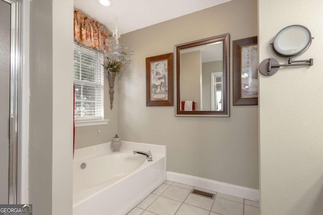 bathroom featuring a garden tub, baseboards, tile patterned floors, and visible vents
