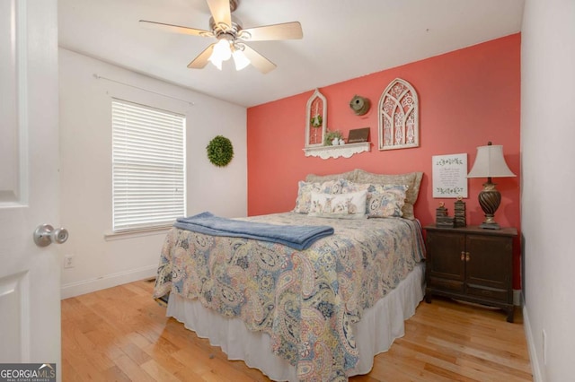 bedroom with baseboards, multiple windows, and light wood finished floors