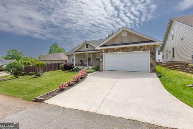 craftsman house featuring fence, stone siding, a garage, a front yard, and concrete driveway