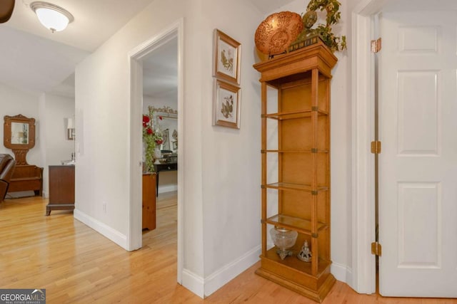 hall featuring baseboards and light wood-type flooring