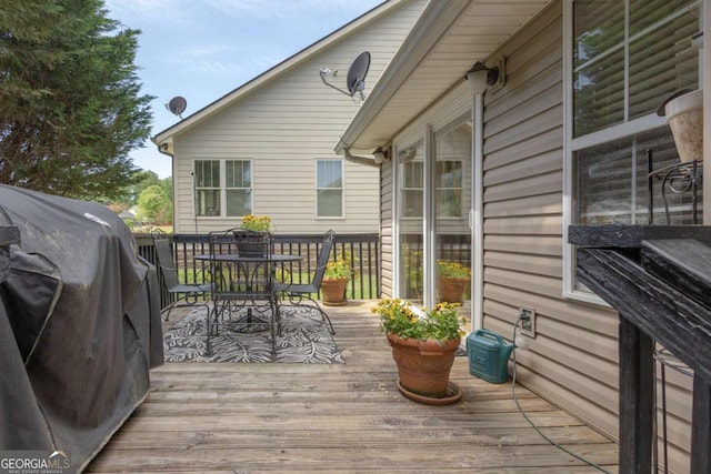 wooden terrace with area for grilling and outdoor dining area