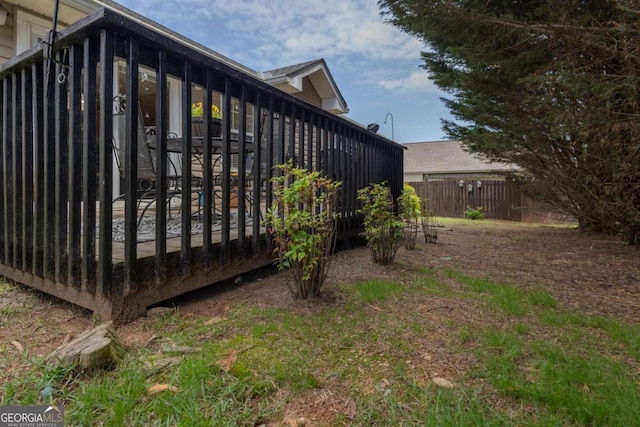 view of property exterior with fence and a wooden deck