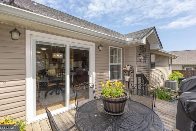 wooden deck featuring outdoor dining area and cooling unit