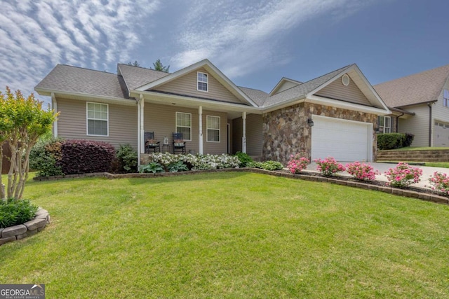 craftsman-style home with covered porch, a front yard, concrete driveway, an attached garage, and stone siding