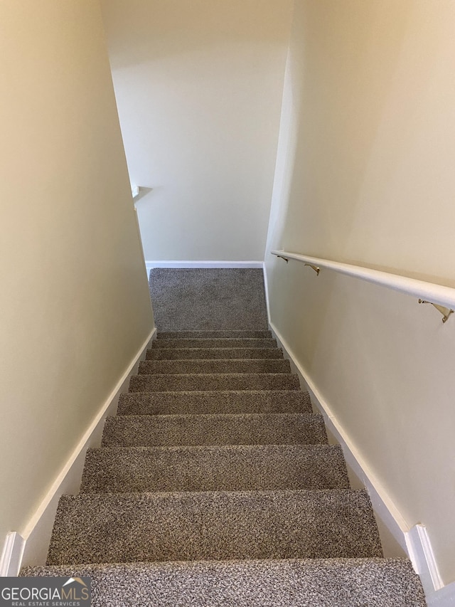 stairs featuring carpet flooring