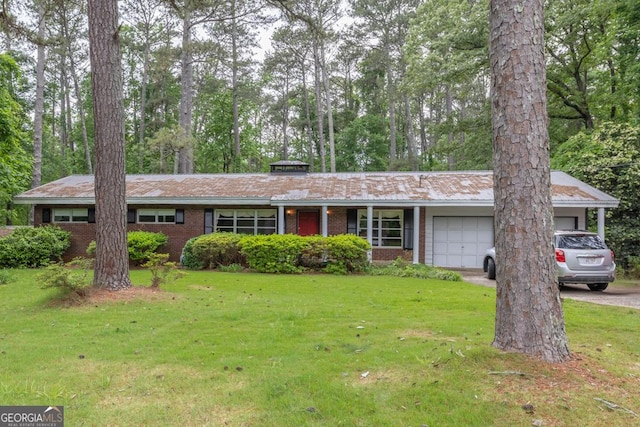 ranch-style home featuring an attached garage, driveway, brick siding, and a front yard