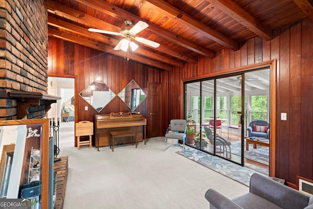 sitting room featuring carpet floors, ceiling fan, wood walls, and wood ceiling