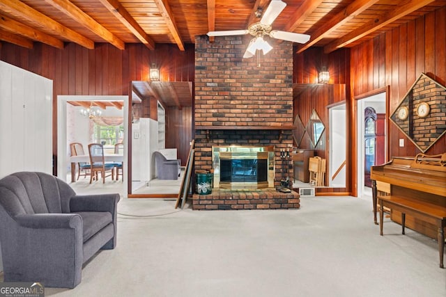 carpeted living area with a brick fireplace, wooden ceiling, beamed ceiling, ceiling fan with notable chandelier, and wooden walls