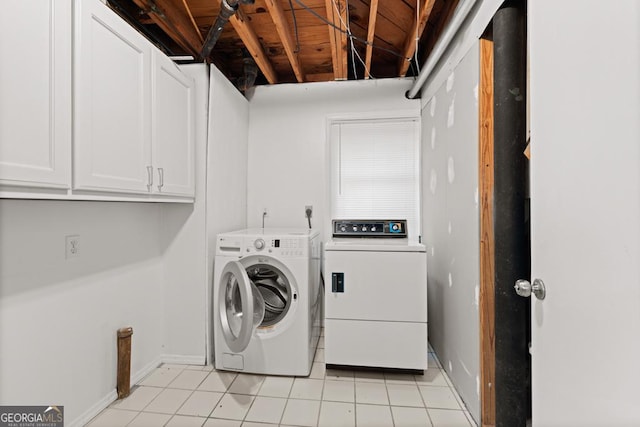 washroom with baseboards, cabinet space, light tile patterned floors, and washing machine and clothes dryer