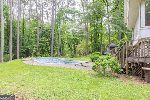 view of yard featuring stairs and an outdoor pool