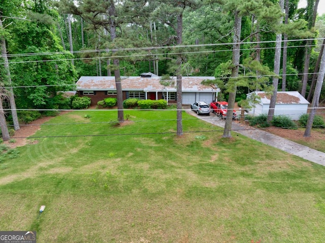 ranch-style house featuring an attached garage, driveway, and a front lawn