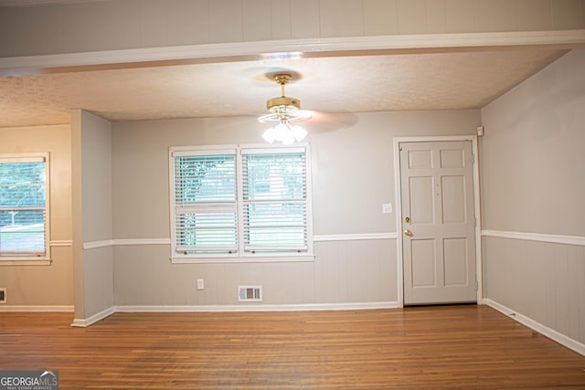 interior space featuring plenty of natural light, a ceiling fan, wood finished floors, and visible vents