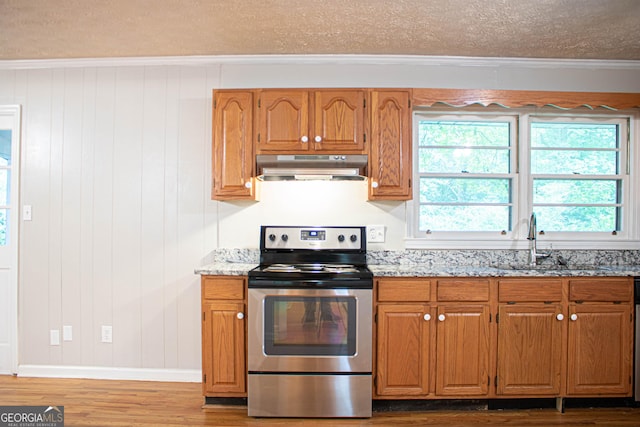 kitchen featuring wood finished floors, electric stove, under cabinet range hood, and light stone countertops