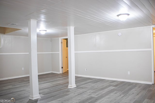 finished basement featuring wooden ceiling, baseboards, and wood finished floors