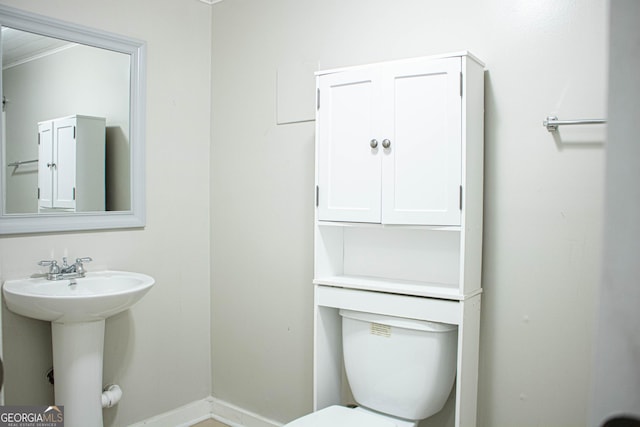 bathroom featuring a sink, baseboards, and toilet