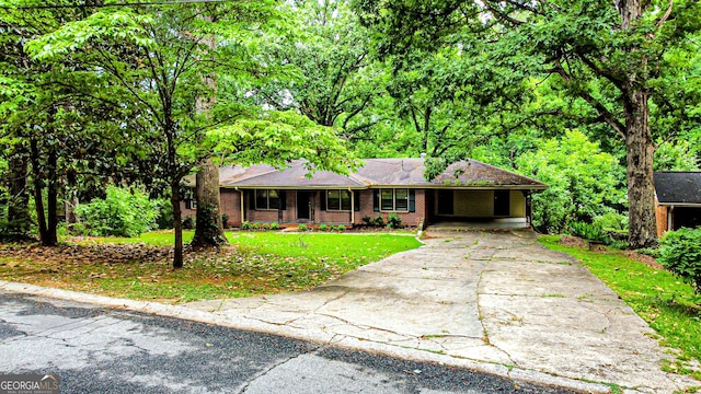 ranch-style house with brick siding, driveway, a front yard, and a carport