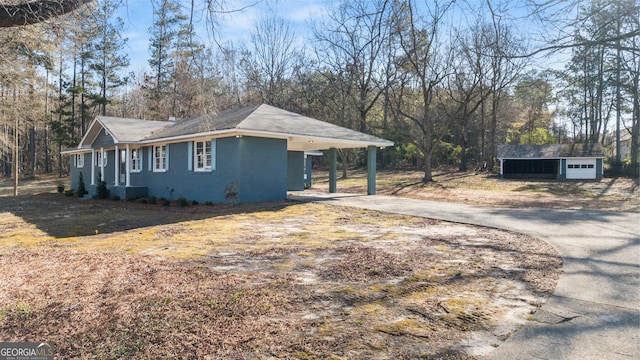 view of home's exterior featuring concrete driveway and a carport