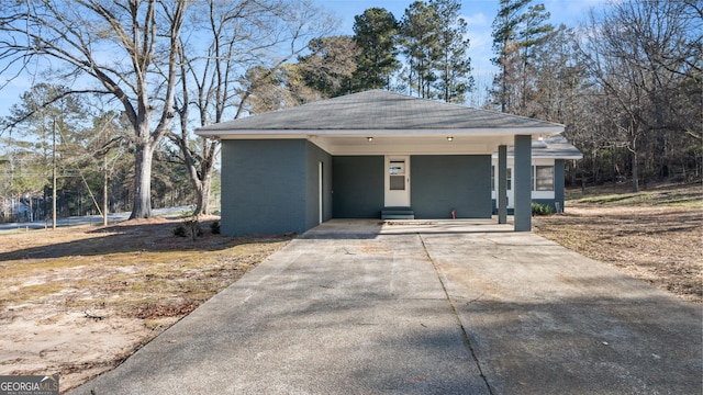 view of front of home featuring brick siding, an attached carport, and concrete driveway