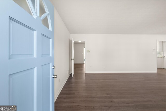 interior space featuring baseboards and dark wood finished floors