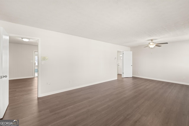 unfurnished living room with baseboards, ceiling fan, and dark wood finished floors