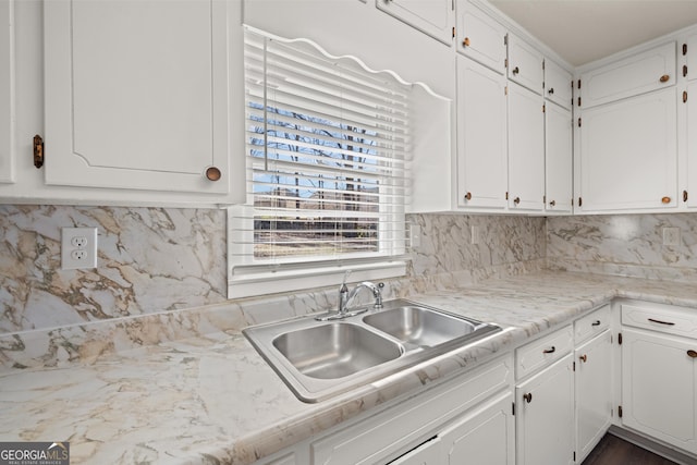 kitchen featuring a sink, decorative backsplash, white cabinets, and light countertops