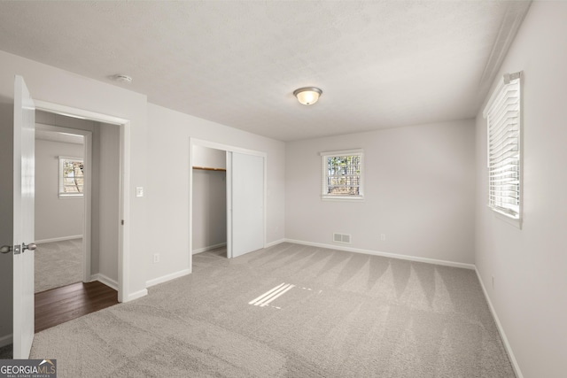 unfurnished bedroom with baseboards, carpet flooring, and multiple windows