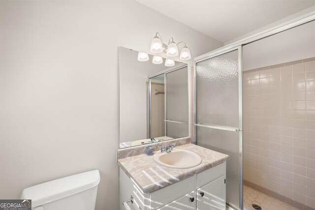 full bathroom featuring vanity, a shower stall, and toilet