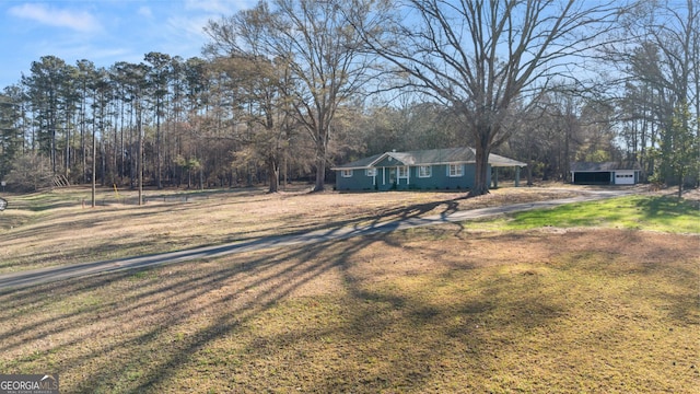 view of front of home with a garage, dirt driveway, and a front yard