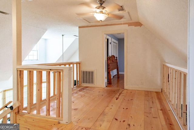 bonus room featuring visible vents, ceiling fan, vaulted ceiling, and hardwood / wood-style floors