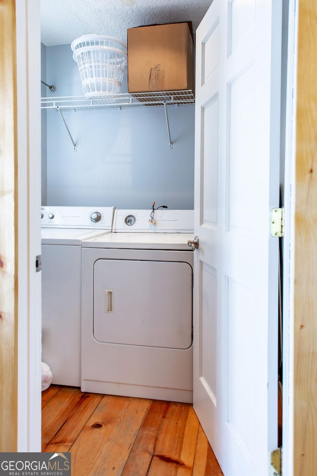laundry area featuring washer and dryer and light wood-type flooring
