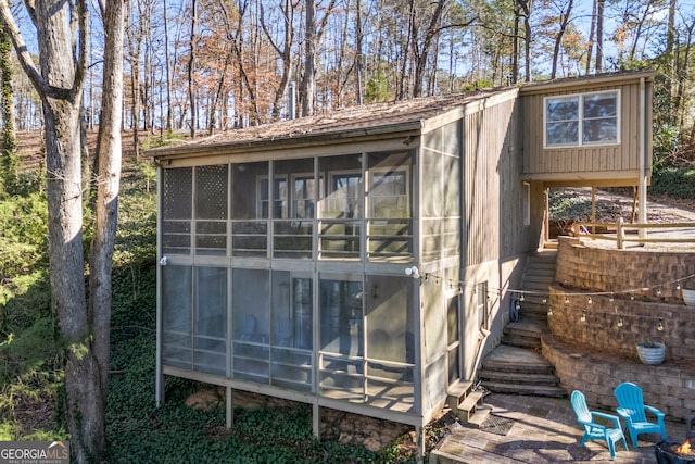 view of outdoor structure with a sunroom and stairway