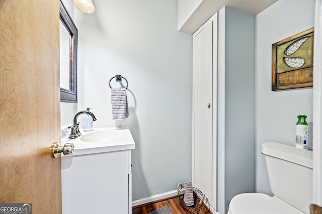 bathroom featuring vanity, wood finished floors, and toilet