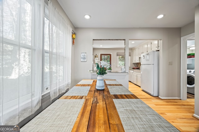 dining area featuring recessed lighting, light wood-type flooring, and washer / clothes dryer