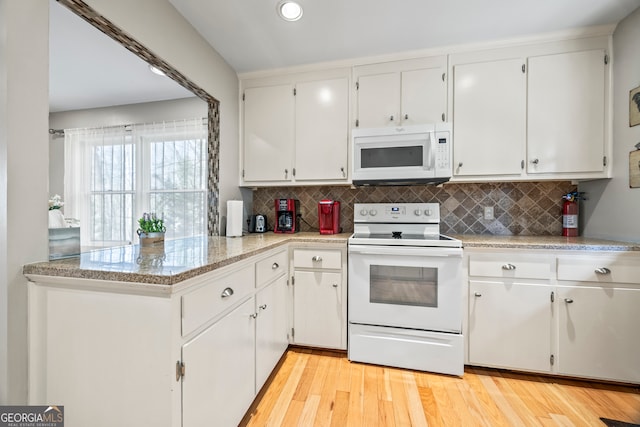 kitchen with tasteful backsplash, white appliances, and white cabinetry