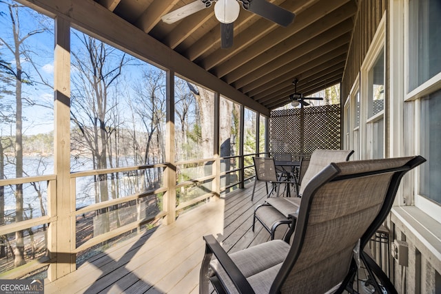 wooden deck featuring a ceiling fan, outdoor dining space, and a water view