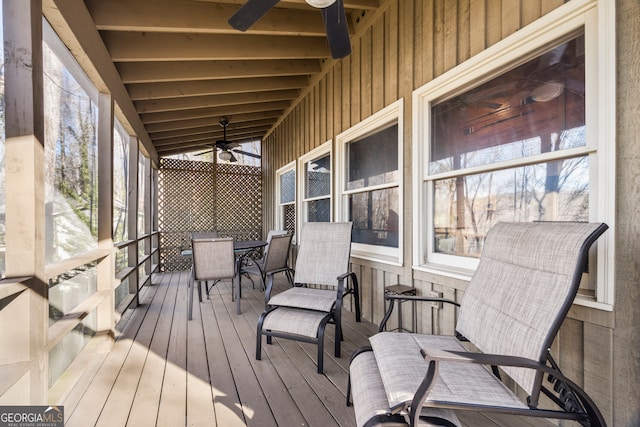 sunroom with outdoor dining area, ceiling fan, and a wealth of natural light