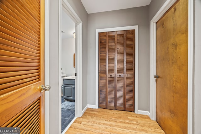 hallway with baseboards and light wood-style flooring
