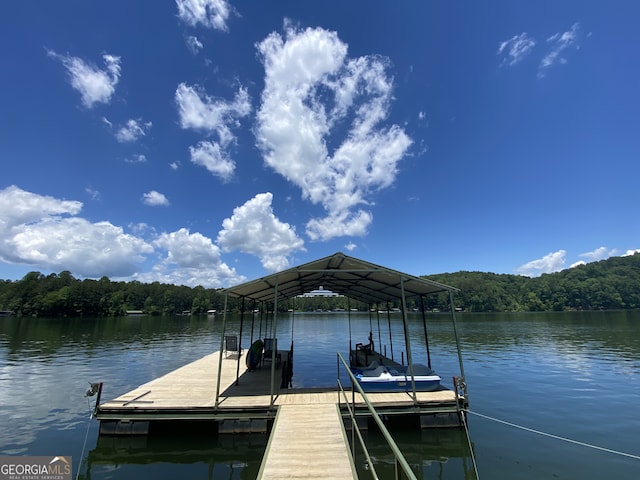 dock area with a view of trees and a water view