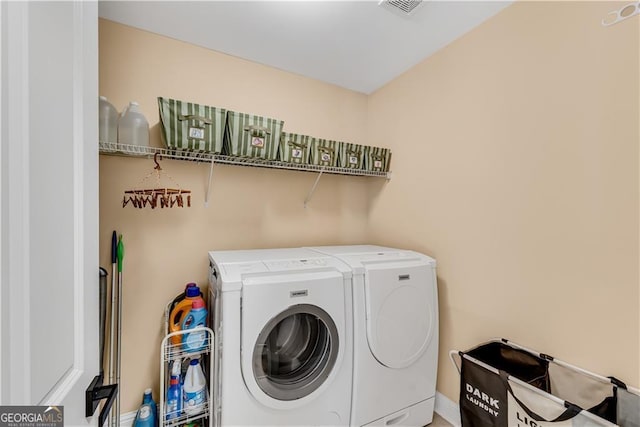 clothes washing area with visible vents, laundry area, and washer and dryer