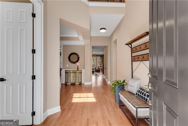 corridor featuring light wood-type flooring and baseboards