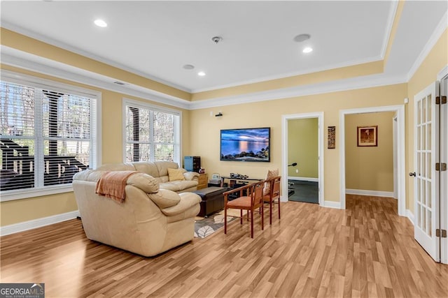 living area featuring crown molding, baseboards, french doors, and light wood-style flooring