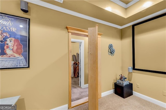 carpeted home theater room with baseboards and ornamental molding
