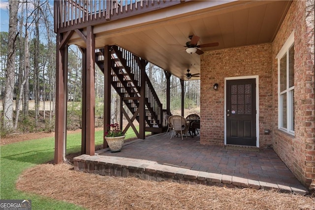 view of patio featuring ceiling fan and stairway