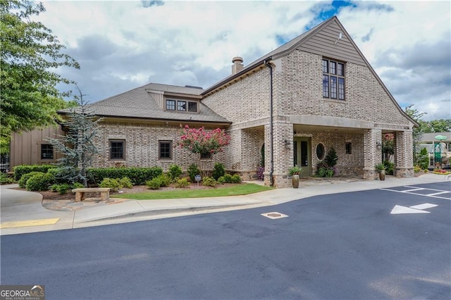 exterior space with brick siding and a chimney